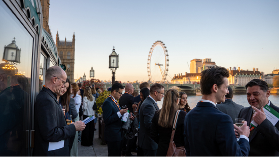 Prize winners gathered on terrace at House of Commons during golden hour with London Eye in background