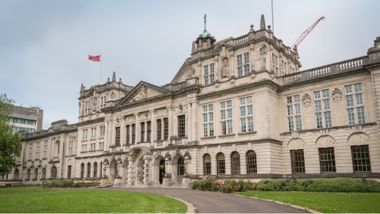 University registry building in Cardiff made of sandstone with red flag flying above it